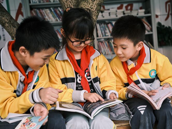 内江明德小学的孩子们在操场上阅读新华文轩供图）.jpg